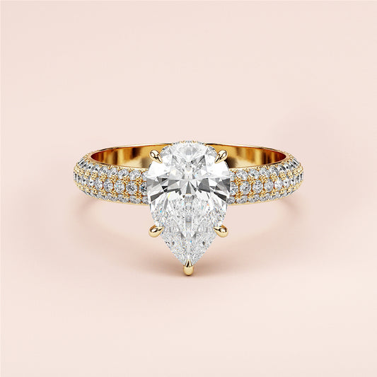 Elegant pear-shaped diamond engagement ring in 14K or 18K gold or platinum, featuringPave accents on the band. Unworn against neutral backdrop.