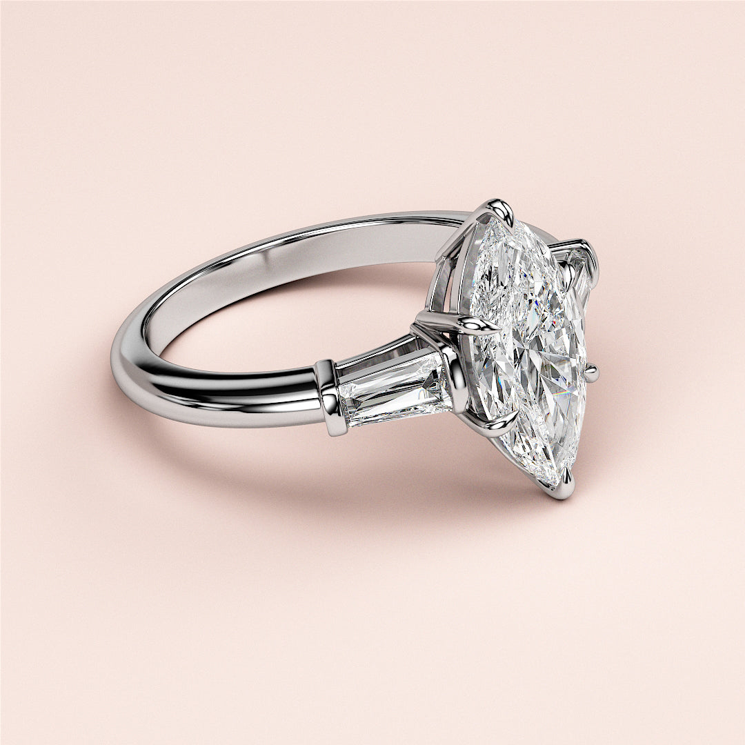 Luxurious 14K/18K white gold engagement ring with marquise-cut diamond and tapered baguette side stones.|
#14KRecycledWhiteGold
#18KRecycledWhiteGold
#Platinum