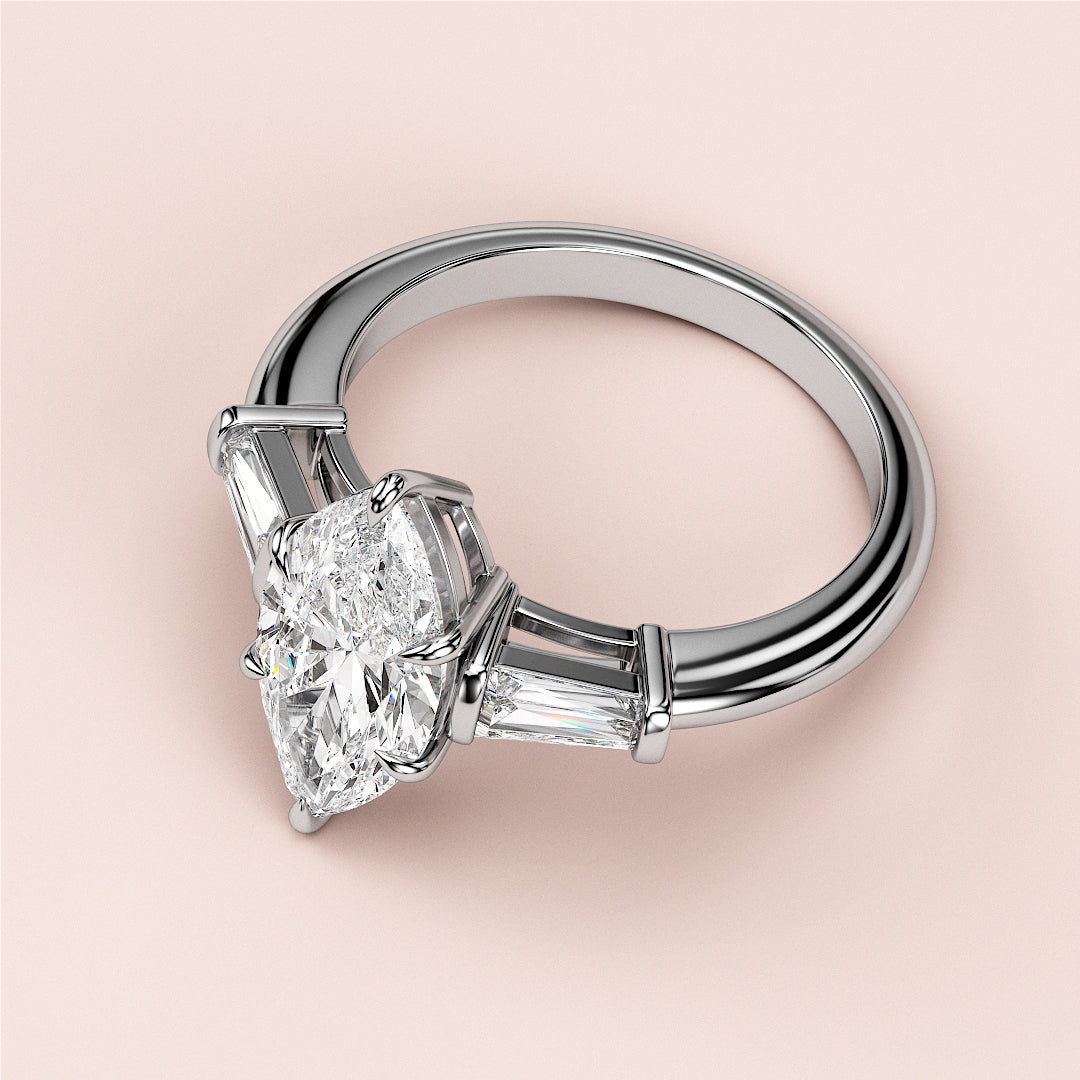 Elegant 14K gold engagement ring featuring a radiant-cut diamond with tapered baguette side stones for a timeless look.|
#14KRecycledWhiteGold
#18KRecycledWhiteGold
#Platinum