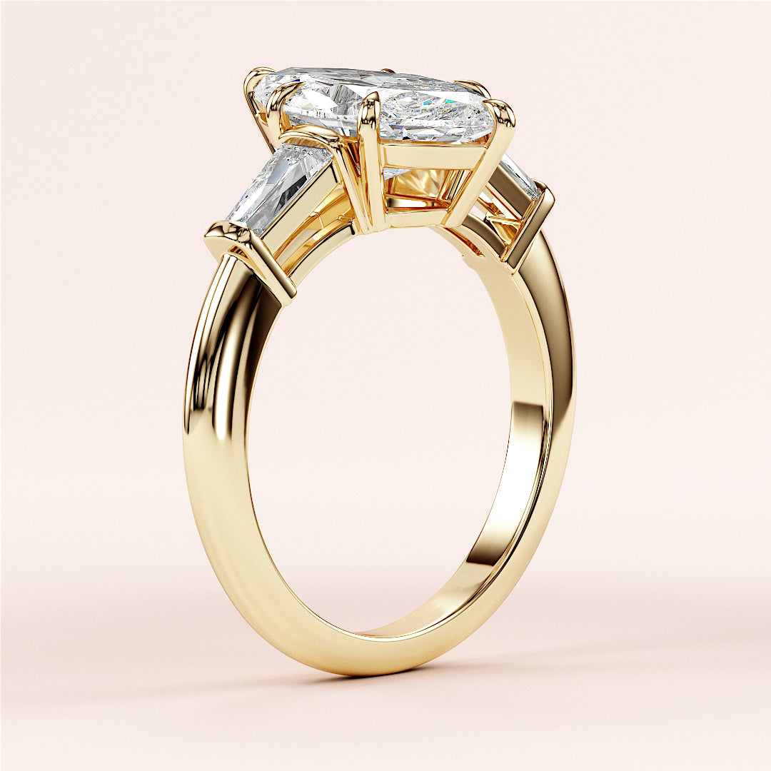 Elegant 14K yellow gold engagement ring with marquise-cut diamond and tapered baguette accents, showcasing exquisite craftsmanship.|
#14KRecycledYellowGold
#18KRecycledYellowGold