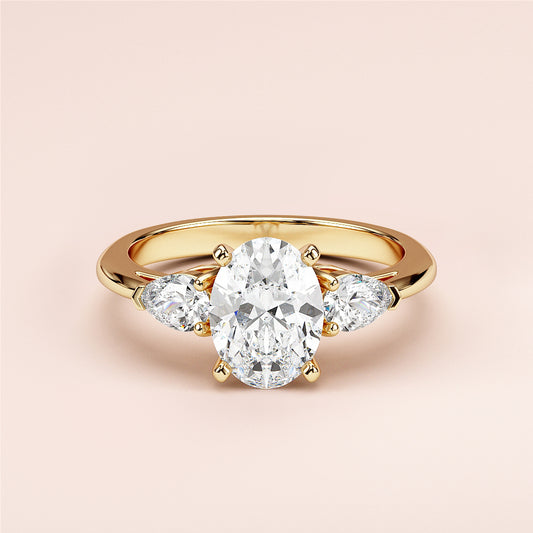 Elegant oval-shaped diamond engagement ring with two pear-shaped side stones, available in 14K or 18K gold or platinum.