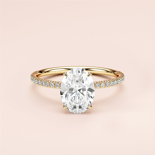 Elegant yellow gold 14K or 18KPave band oval diamond engagement ring, showcasing a stunning center stone, worn on a model.