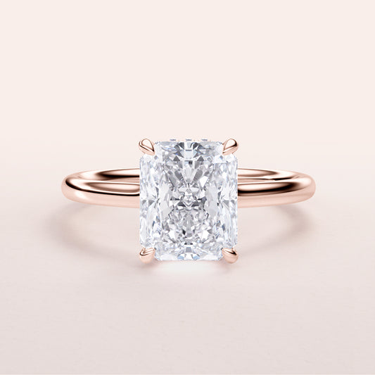 Radiant cut diamond engagement ring in rose gold band, available in 14K, 18K, or platinum. Elegant solitaire, sparkling design.
