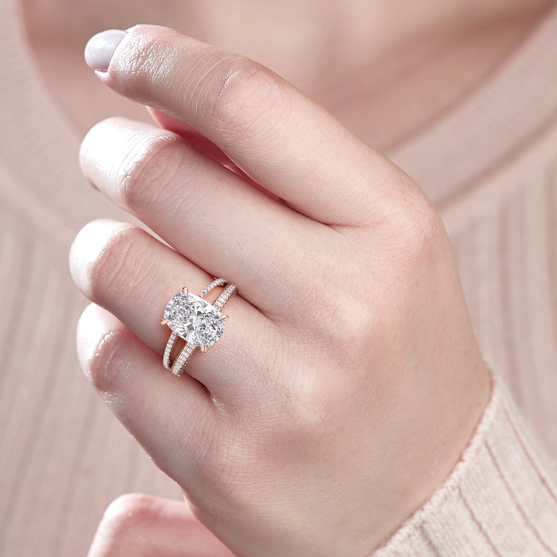 Close-up of a model's hand wearing a luxurious 14K rose gold engagement ring with a cushion diamond and matching wedding band.|
#14KRecycledRoseGold
#18KRecycledRoseGold