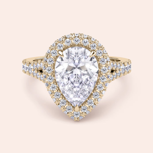 Pear shaped halo diamond ring in yellow gold with pavé band, elevated setting with detailed side profile and elegant structure 