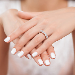 Heart diamond eternity ring in rose gold worn on hands, delicate stacking band with continuous heart shaped diamonds and refined sparkle 