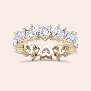 Yellow gold heart diamond eternity ring, angled product view showcasing prong setting and seamless row of heart shaped diamonds 