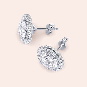 White gold halo diamond stud earrings worn on ear, lifestyle close-up highlighting sparkle, elegance and everyday luxury appeal 
