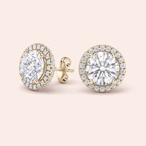 Matching pair of signature round halo diamond stud earrings in yellow gold, symmetrical layout emphasizing balance and brilliance 