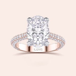 Oval solitaire diamond engagement ring in rose and white gold, top view with pavé band and claw prong setting 