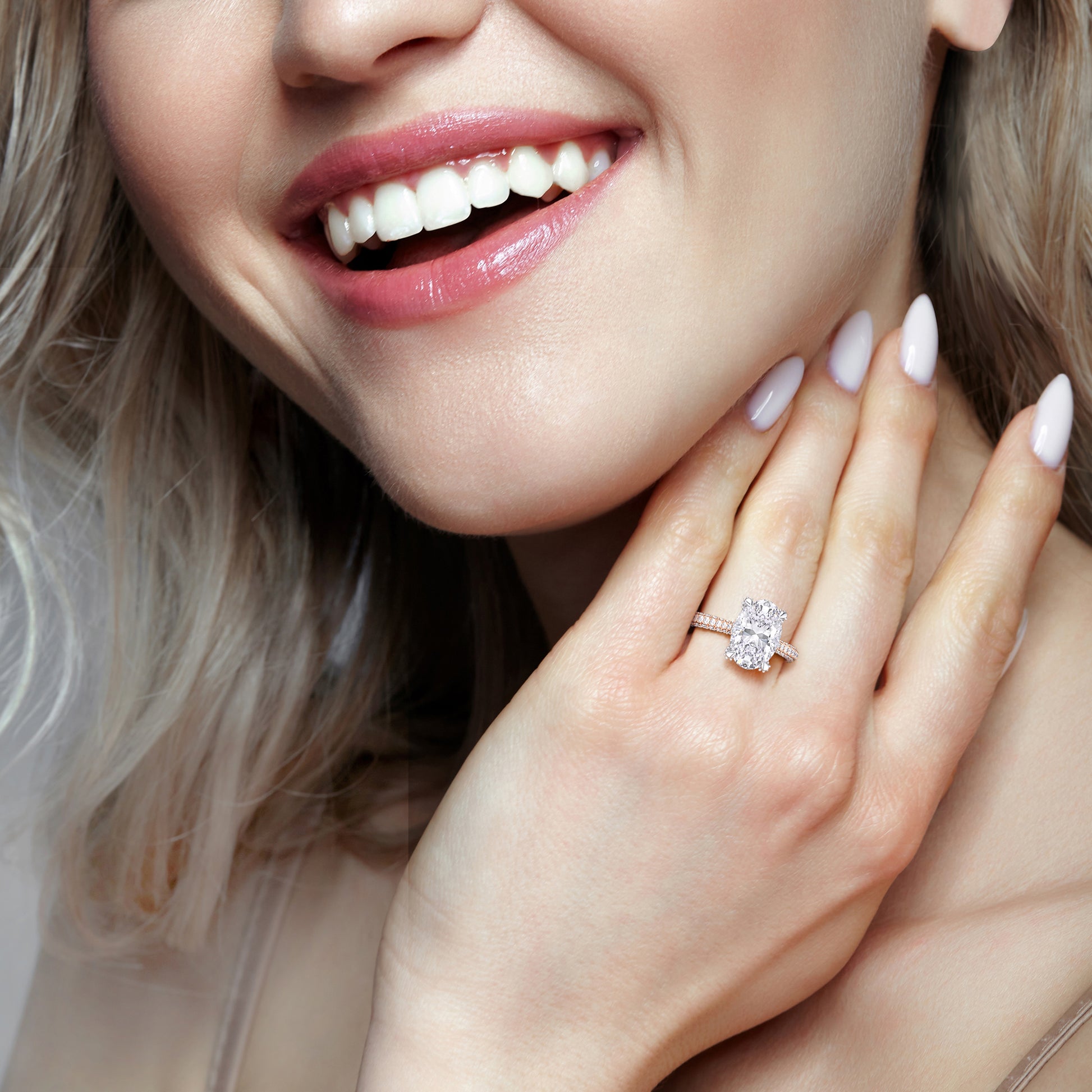 Two tone oval diamond engagement ring on smiling model hand, bridal jewelry close-up with mixed metal setting | #14KRecycledRose/WhiteGold #18KRecycledRose/WhiteGold