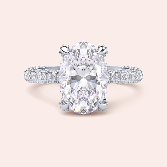 White gold oval diamond engagement ring, front view with pavé band and cat claw prongs 
