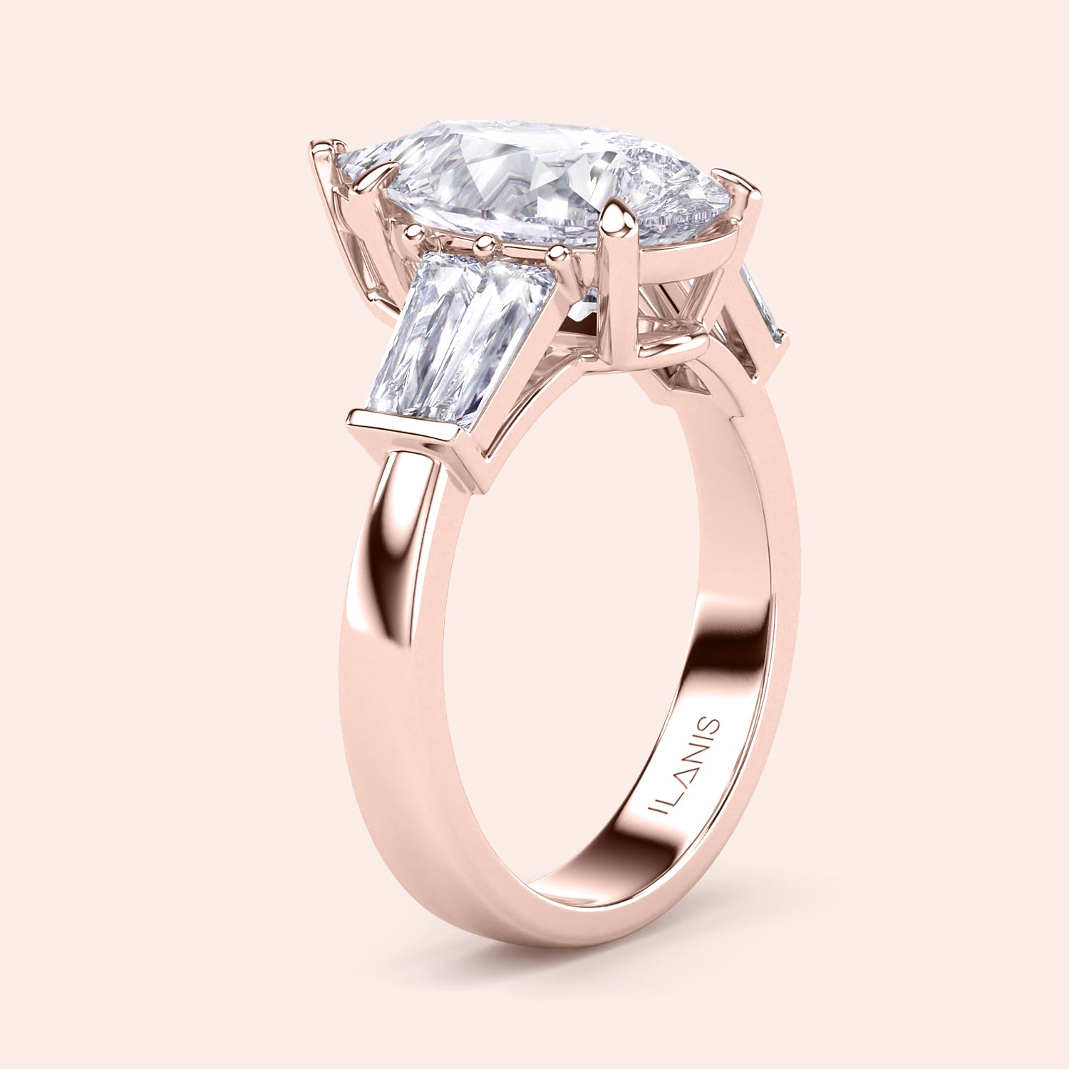 Pear shaped diamond engagement ring in rose gold, side angle showcasing three stone design with tapered baguette side diamonds | #14KRecycledRoseGold #18KRecycledRoseGold