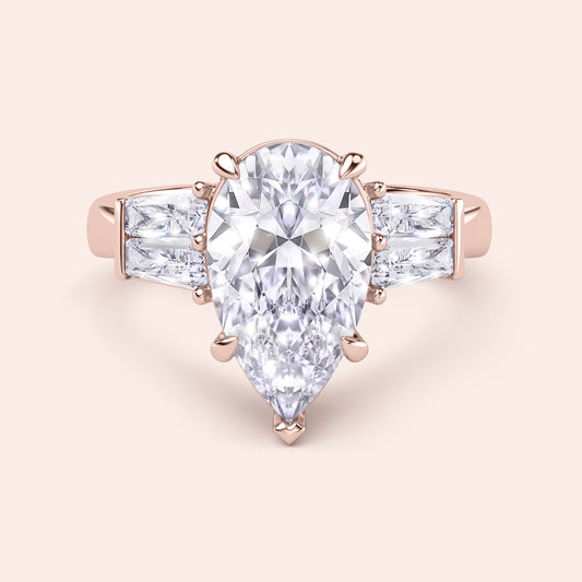 Pear cut diamond three stone ring in rose gold, top view with elegant prong setting and baguette side diamonds 