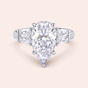 Pear diamond three stone ring in white gold, top view highlighting symmetry of center stone and baguette side diamonds 