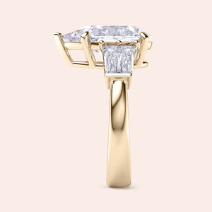 Pear cut diamond engagement ring in yellow gold, side angle showing prong setting and architectural gallery design 