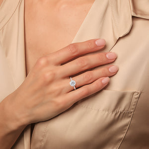 Rose gold solitaire diamond ring with pavé band styled on hand against neutral tones, emphasizing refined proportions and timeless design 