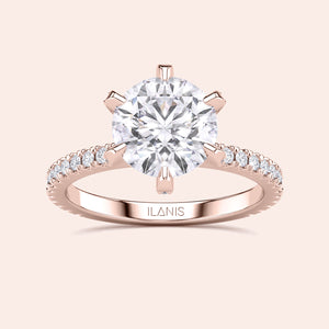 Front view of round brilliant diamond engagement ring in rose gold with pavé band, showcasing center stone fire and symmetry 