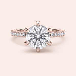 Top view close-up of rose gold round diamond engagement ring with pavé band, emphasizing diamond cut, sparkle and prong alignment 