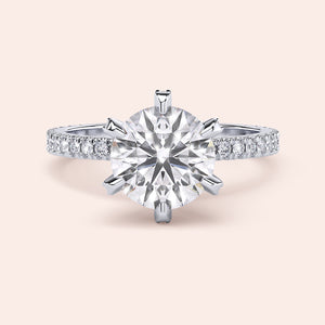 Front view of round brilliant diamond engagement ring in white gold or platinum with pavé band, showcasing maximum brilliance and symmetry 