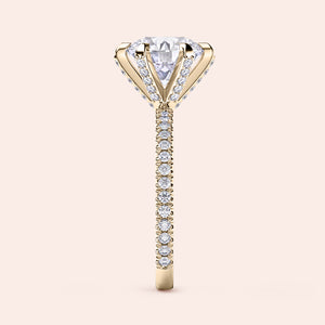 Front view of round brilliant diamond engagement ring in yellow gold with pavé band, showcasing brilliance, symmetry and warm tones 