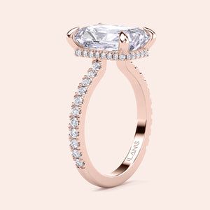 Close-up of radiant cut diamond engagement ring in rose gold with pavé band, highlighting prong setting, fine detailing and natural glow 