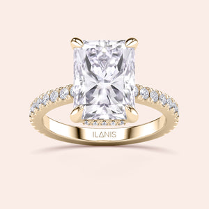 Top view close-up of radiant cut diamond engagement ring in yellow gold with pavé band, emphasizing cut precision, fire and prong detailing 