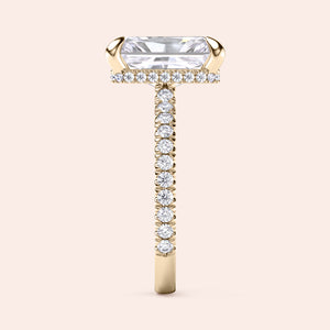 Side profile of yellow gold radiant cut diamond engagement ring with pavé band and accent diamonds on prongs, showing elevated gallery design 