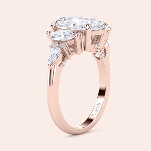 Oval diamond three stone engagement ring yellow gold side profile with pear side stones, elevated setting detail, handcrafted luxury engagement ring design 