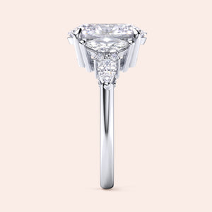 White gold oval diamond three stone engagement ring side profile with pear side stones, elevated setting and fine craftsmanship detail 