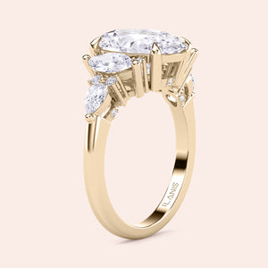 Yellow gold oval three stone diamond engagement ring vertical side view with pear side stones, detailed craftsmanship and refined structure 