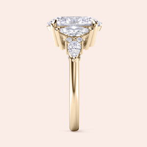 Oval cut three stone diamond engagement ring yellow gold front view with pear side stones, brilliant oval center diamond, luxury bridal ring design 