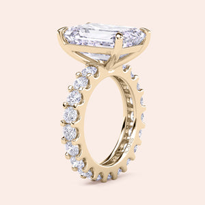 Emerald cut diamond engagement ring yellow gold with full eternity diamond band, side profile view, modern hidden setting, luxury bridal ring 