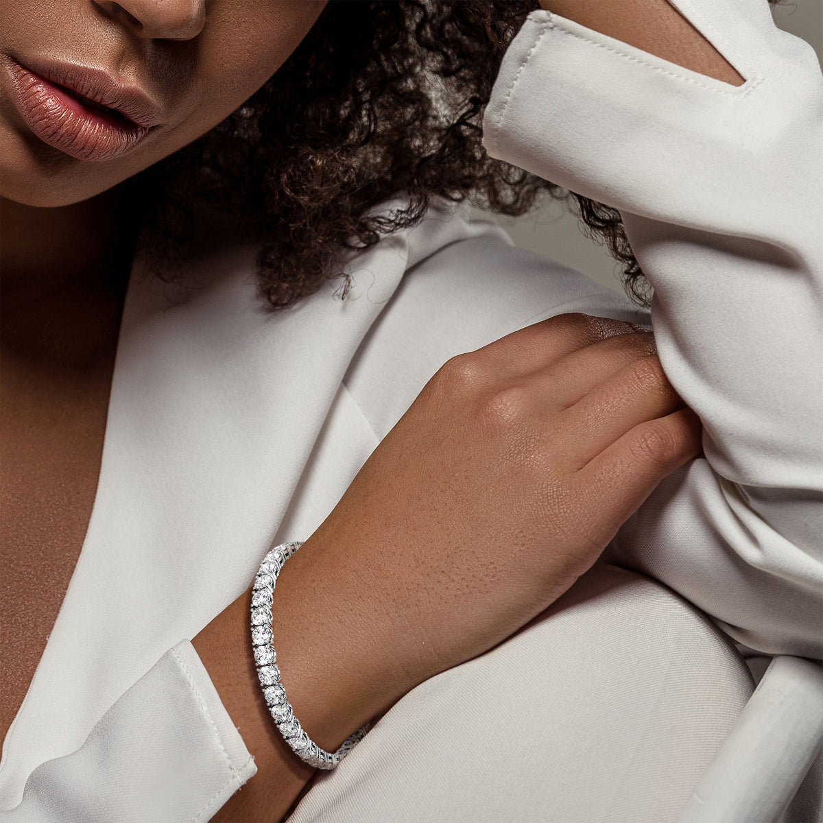 Diamond tennis bracelet on model featuring round brilliant cut diamonds in a secure four-prong setting. Available in 14K or 18K white, yellow, or rose gold. Timeless luxury and radiant sparkle for any occasion. 