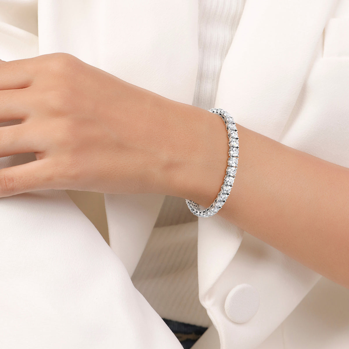 Diamond tennis bracelet on model featuring round brilliant cut diamonds in a secure four-prong setting. Available in 14K or 18K white, yellow, or rose gold. Timeless luxury and radiant sparkle for any occasion. 
