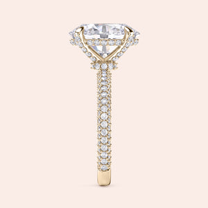 Pear diamond engagement ring in yellow gold with three stone setting, side angle showing prong setting and clean architectural lines 