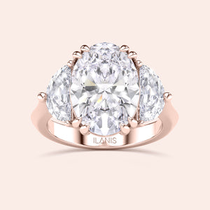Oval shaped diamond ring in rose gold, top view highlighting brilliance of center diamond and symmetry of pear side stones 