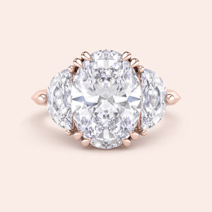 Oval cut diamond engagement ring in rose gold with pear side diamonds, classic three stone design with brilliant center stone 
