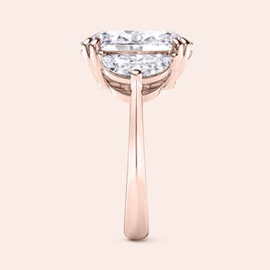 Oval diamond engagement ring in rose gold with three stone setting, side angle showing prong setting and clean elegant structure 