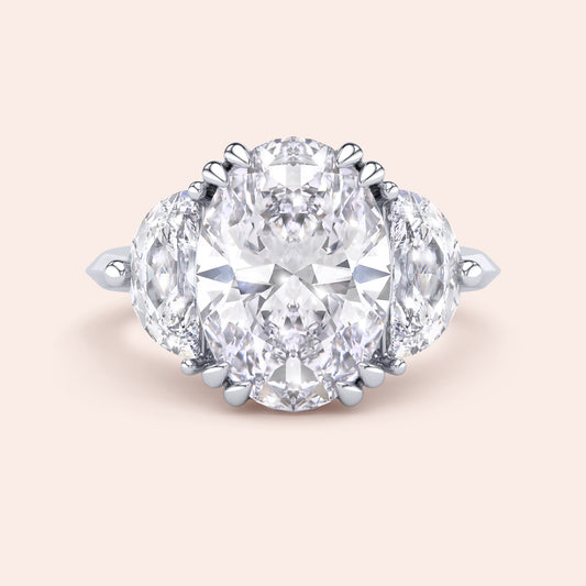 Oval cut diamond engagement ring in white gold with pear side diamonds, classic three stone design with brilliant center stone 