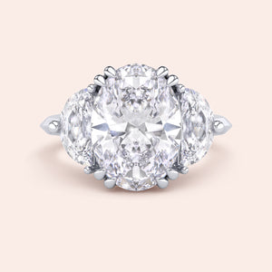 Oval cut diamond engagement ring in white gold with pear side diamonds, classic three stone design with brilliant center stone 