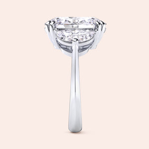 Oval diamond engagement ring in white gold with three stone setting, side angle showing prong setting and clean elegant structure 