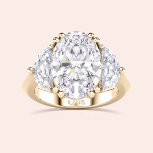 Oval shaped diamond ring in yellow gold, top view highlighting brilliance of center diamond and symmetry of pear side stones 