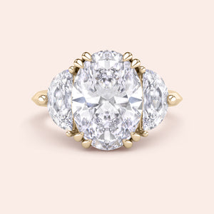 Oval cut diamond engagement ring in yellow gold with pear side diamonds, classic three stone design with brilliant center stone 
