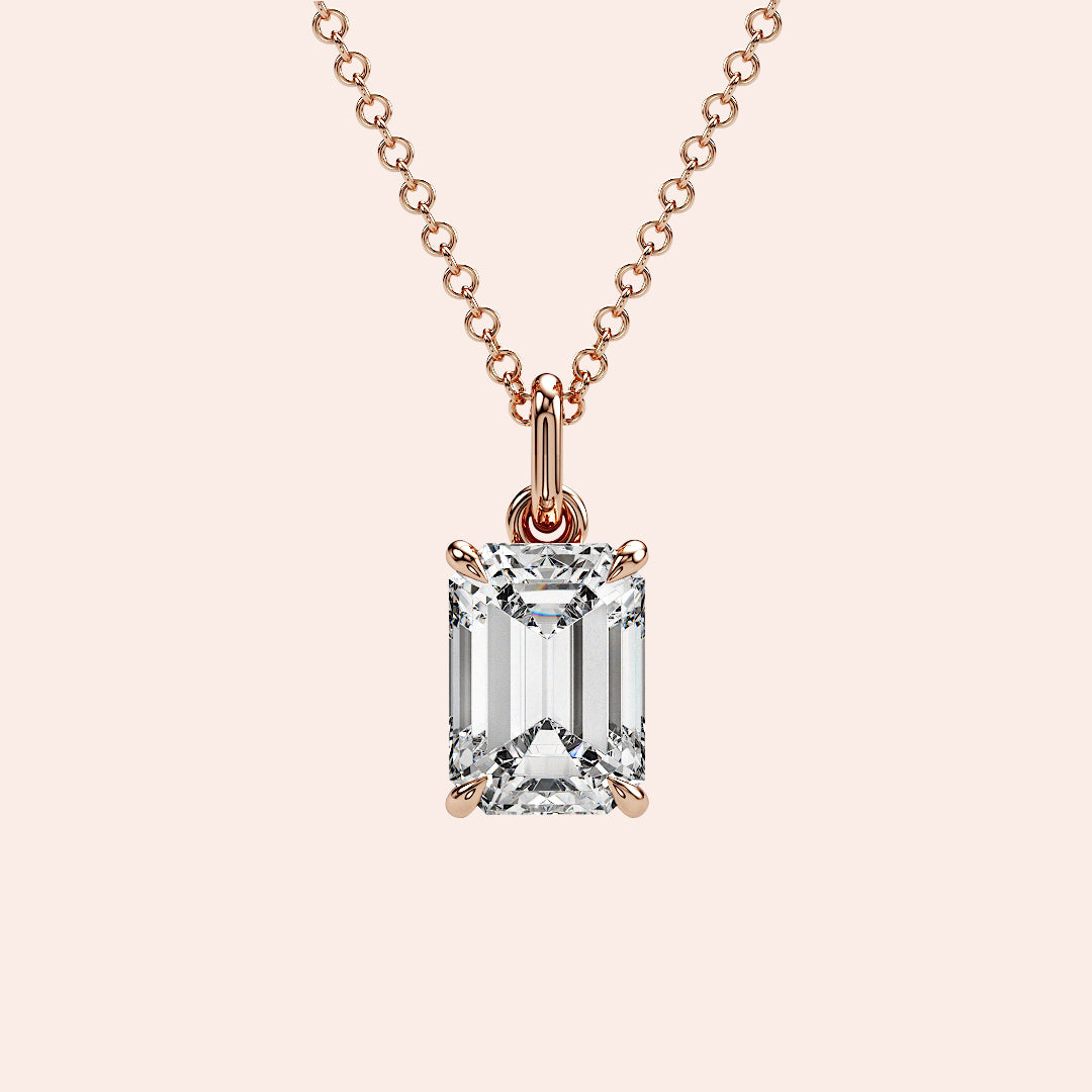 A detailed side view of an emerald-cut diamond solitaire pendant in a four-prong rose gold basket setting. The intricate craftsmanship and secure setting highlight the beauty and precision of this classic piece.
| #14KRecycledRoseGold #18KRecycledRoseGold

