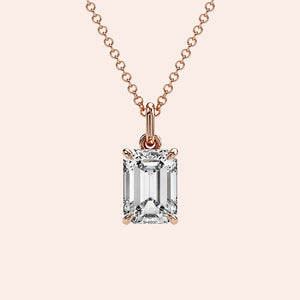 A detailed side view of an emerald-cut diamond solitaire pendant in a four-prong rose gold basket setting. The intricate craftsmanship and secure setting highlight the beauty and precision of this classic piece.
