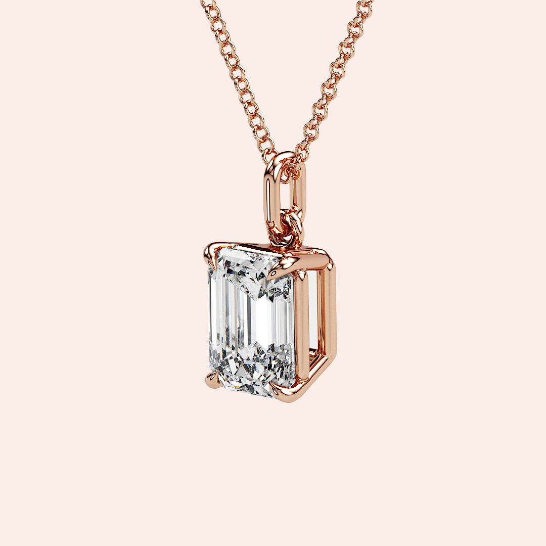 A stylish woman wearing a solitaire emerald-cut diamond pendant in rose gold. The pendant’s elongated shape and clean facets make it a perfect choice for those who love modern elegance with a vintage touch.
| #14KRecycledRoseGold #18KRecycledRoseGold