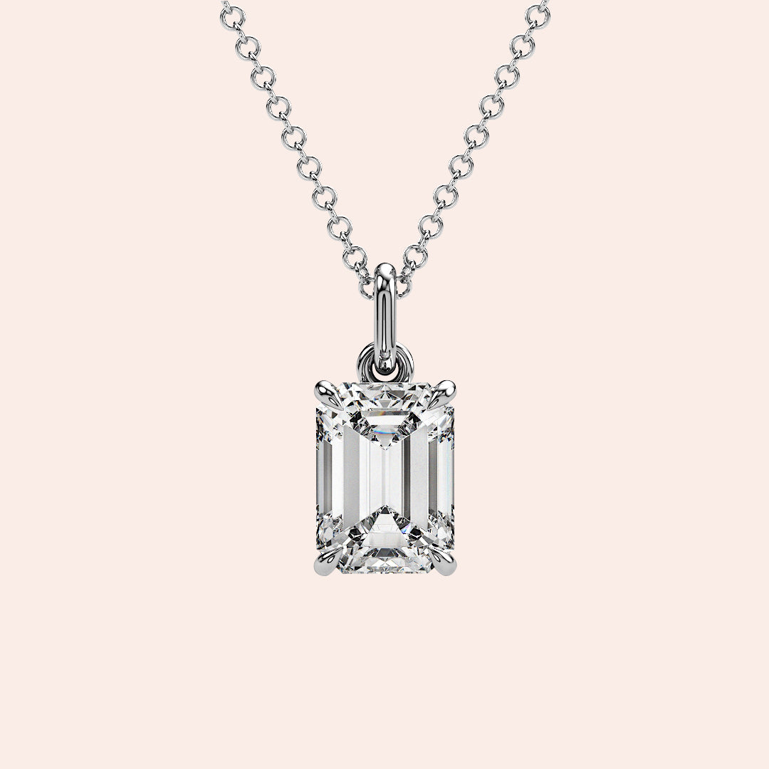 A close-up of a solitaire emerald-cut diamond pendant in a four-prong white gold setting. This elegant and modern design enhances the diamond’s brilliance while maintaining a minimalist aesthetic.
| #14KRecycledWhiteGold #18KRecycledWhiteGold