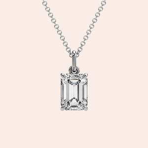 A close-up of a solitaire emerald-cut diamond pendant in a four-prong white gold setting. This elegant and modern design enhances the diamond’s brilliance while maintaining a minimalist aesthetic.
