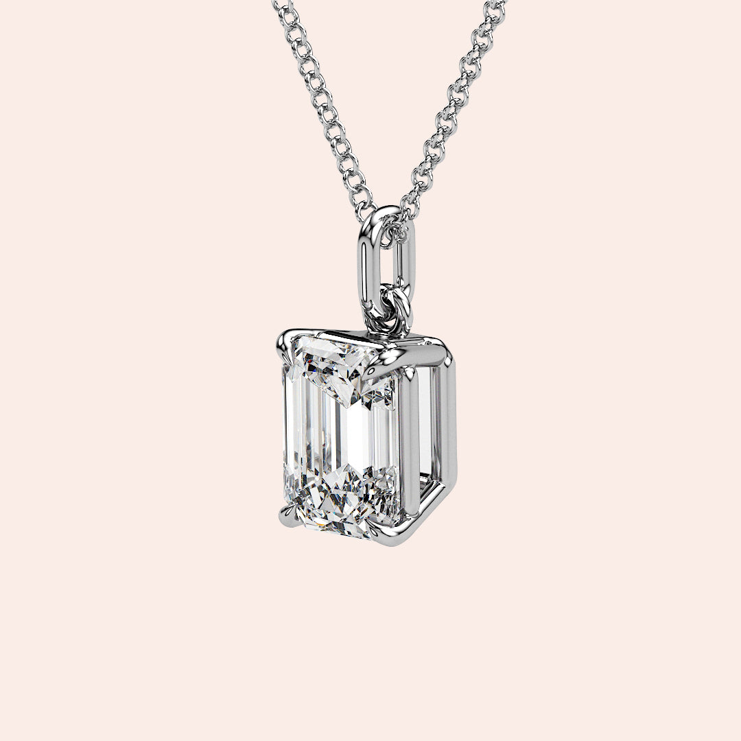 A detailed side view of an emerald-cut diamond solitaire pendant in a four-prong white gold basket setting. The intricate craftsmanship and secure setting highlight the beauty and precision of this classic piece.
| #14KRecycledWhiteGold #18KRecycledWhiteGold